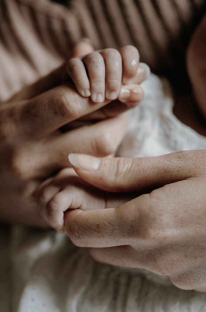 Main de bébé et maman de très proche, arrière plan flouté