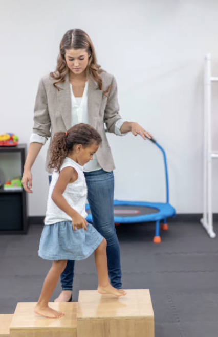 Ergothérapeute aide enfant à monter des marches
